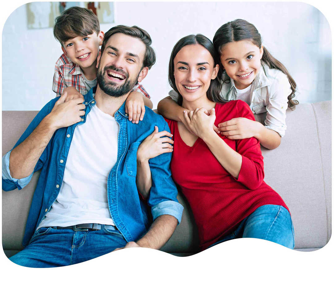 Eine vierköpfige Familie lacht in die Kamera Eine vierköpfige Familie lacht in die Kamera