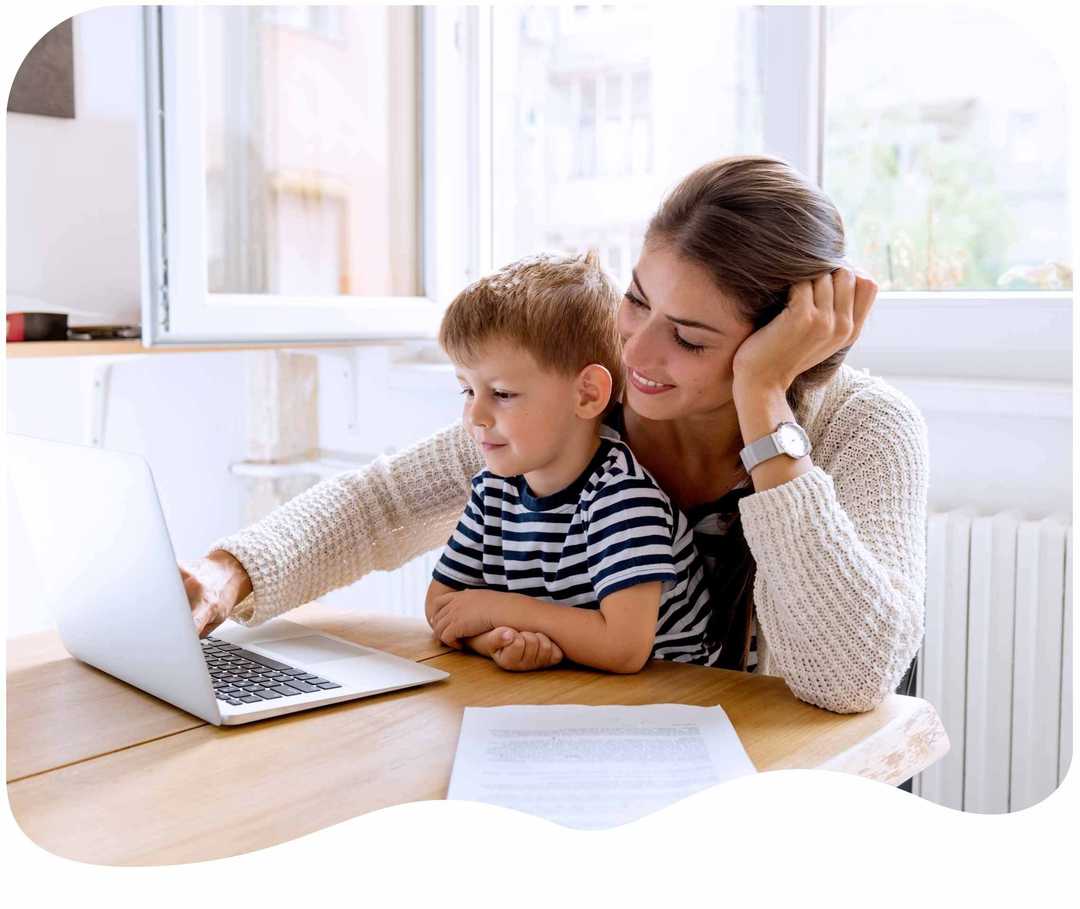 Mutter sitzt mit ihrem Sohn vor einem Laptop Mutter sitzt mit ihrem Sohn vor einem Laptop